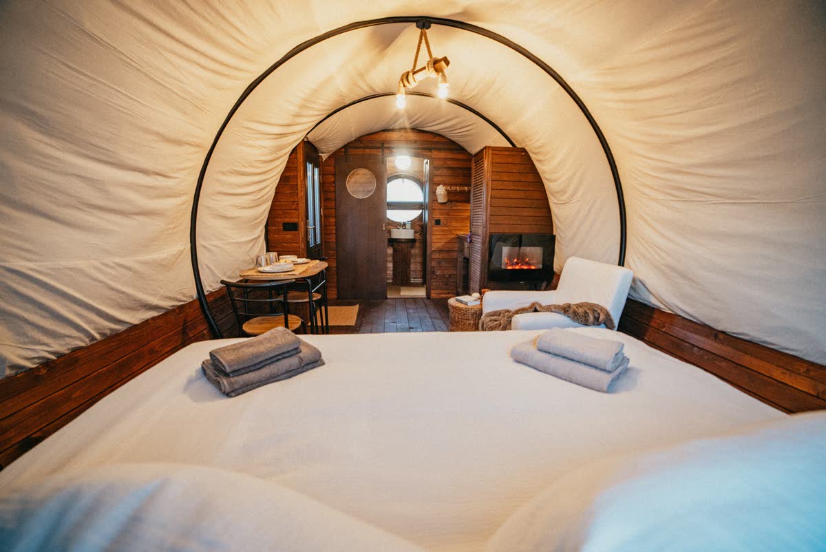 Franciaágy a glamping szekérben, ágyneművel és olvasólámpával